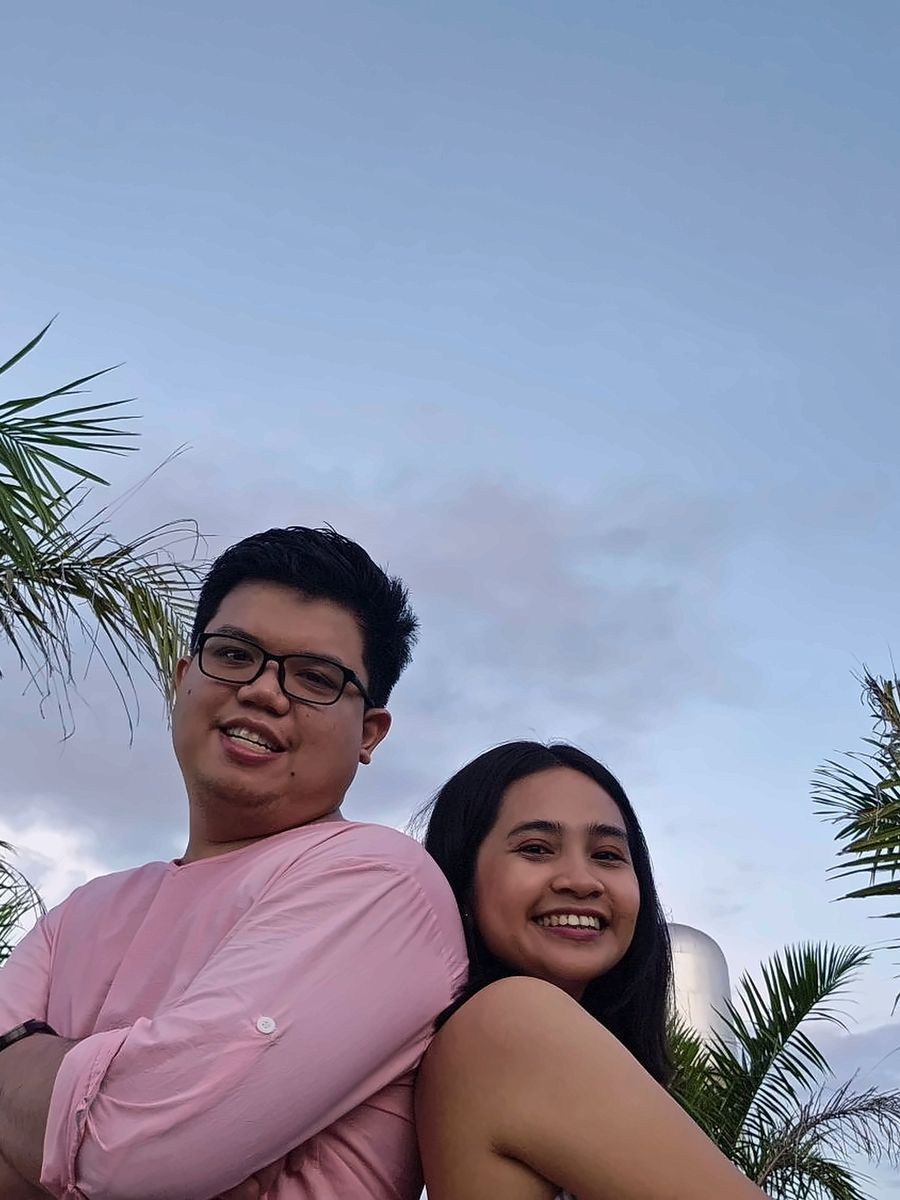 Roi and Geselle standing back to back under palm trees